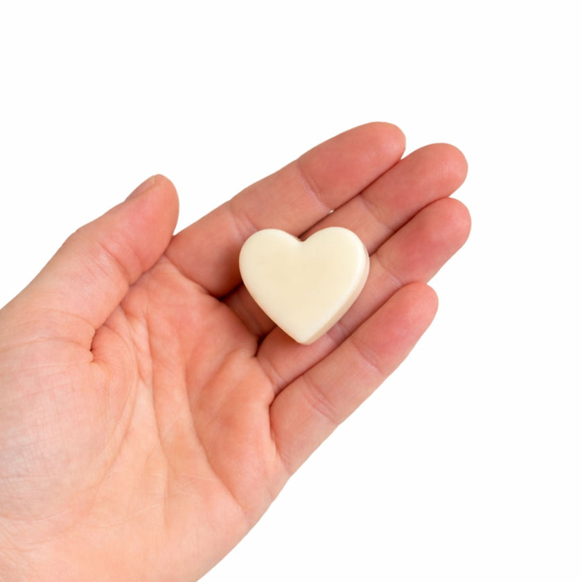 Wax melt Luz Serena en forma de corazón blanco sostenido en la mano