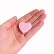 Corazón de cera rosa Abrazo del Alma sostenido en la mano, símbolo de amor propio y ternura.